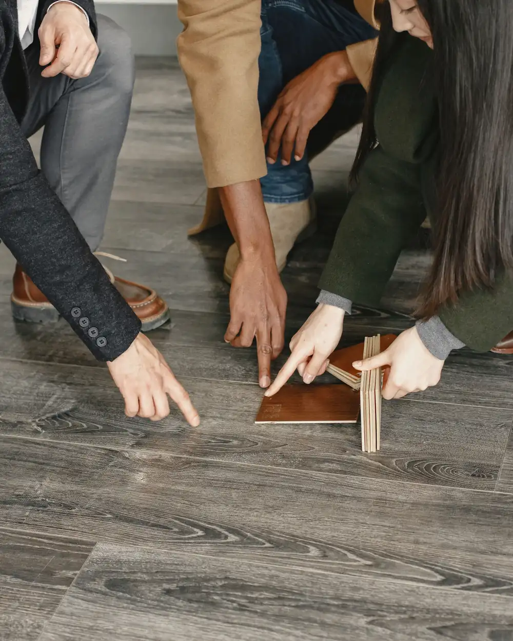 Hands comparing unbranded wood-look flooring samples
