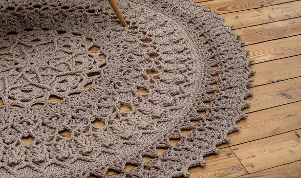 Round crochet area rug on a wooden floor
