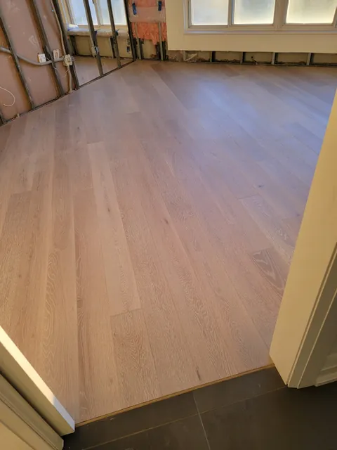 New engineered hardwood laid through the room and finished at the tile doorway, Toronto condo