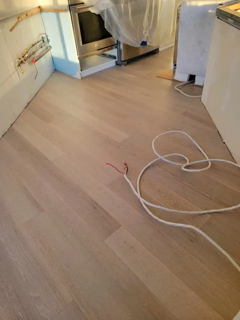 New engineered hardwood in front of the kitchen range and cabinets, Toronto condo after water damage