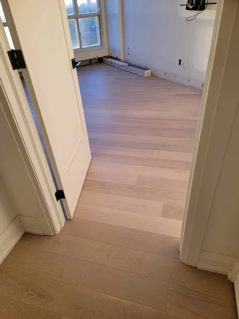 New engineered hardwood seen through an open doorway into the next room